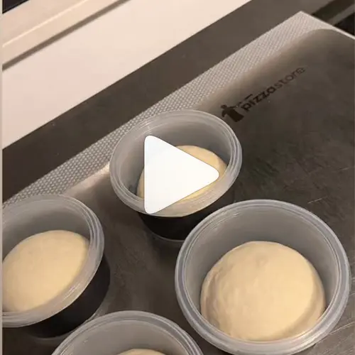Vier pizzadeegbollen in bakjes, klaar voor de koude rijs